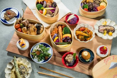 Japon usulü ızgara balık, pirinç köftesi, sebze, tempura, salata ve tatlı içeren bir yemek..