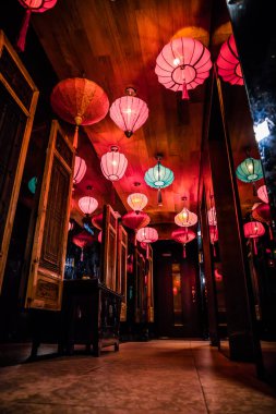 Kırmızı, pembe ve turkuaz fenerlerle, ahşap paneller, aynalar ve fayanslarla süslü zengin bir koridor..