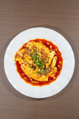 Sichuan usulü haşlanmış tavuk, acı biber yağı, ezilmiş fıstık, susam tohumu ve yeşil soğan..