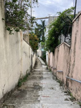 Eski duvarlar ve yeşilliklerle sarp bir ara sokak modern bir köprü ve şehir binalarına açılıyor..