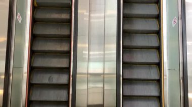 Yoğun bir tren istasyonunda sabah trafiğinde yürüyen yürüyen merdivenler.