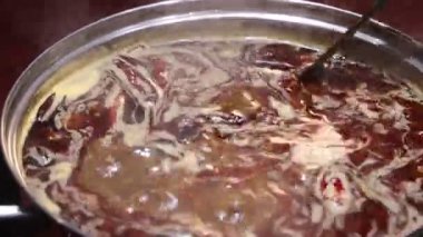 Canlı bir restoran ortamında kaynayan kıvrımlı renkleri ve cızırdayan sıcak tencerenin zengin lezzetlerini tecrübe edin.