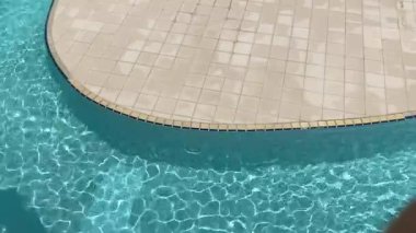 Yazın sıcak güneşin altında, parlayan havuz başında vahanın tadını çıkarıyorum.