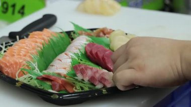Taze suşi hazırlığı canlı malzemeler ve yetenekli ellerle canlı bir piyasa ortamında sanatsal bir tabak yaratıyor.