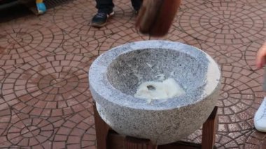 Canlı bir açık hava ortamının sıcak güneşi altında geleneksel bir taş havan topu içinde lezzetli hamurlar yaratmak.