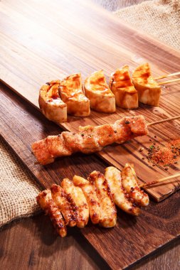 Üç şişe ızgara daikon, baharatlı ve susamlı tavuk ve sade bir pano..