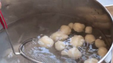 Güneşli bir mutfakta fokurdayan bir tencerede lezzetli hamur tatlısı yapma sanatını keşfedin.