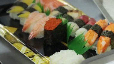 Suşi börekleri ve renkli nigiri hazırlamak öğle yemeği saatinde hareketli bir suşi mutfağında.
