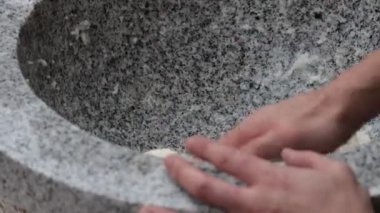 Kırsalın göbeğindeki sıcak bir mutfakta geleneksel bir taş havan topunu elle yoğurmak.