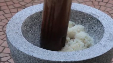 Güneşli bir öğleden sonra manzaralı bir ortamda geleneksel pirinç vurma sanatını keşfedin.