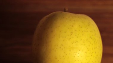Sıcak ışık altında, sıcak bir mutfak ortamında zarif bir şekilde dönen olgun bir armutun canlı güzelliğini keşfedin.