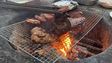 Canlı bir arka bahçede alevler içinde ızgara et yemek arkadaşlarla ve ailelerle yaz toplantılarının özünü yansıtıyor.