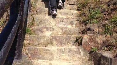 Güneşli bir günde manzaralı bir dağ yolunun kayalık patikalarını keşfediyorum.