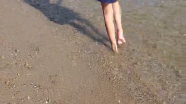 Güneşli bir günün tadını çıkarıyorum. Sıcak sahil boyunca yalınayak yürürken kumlu sahilde hafif dalgalar dolaşırken.