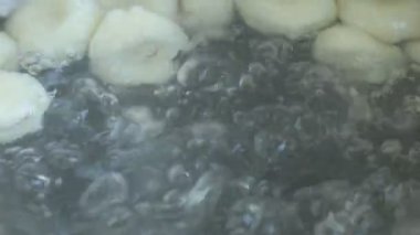 Hamur toplarının lezzetli bir aşçılık deneyimi için kaynar suya dönüşmesini izlemek.
