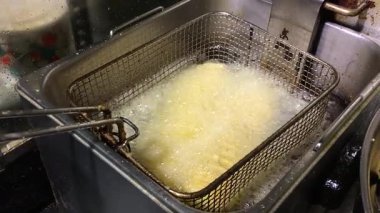 Kıtır kıtır patatesler yemek telaşı sırasında kızgın yağda dönüşür.