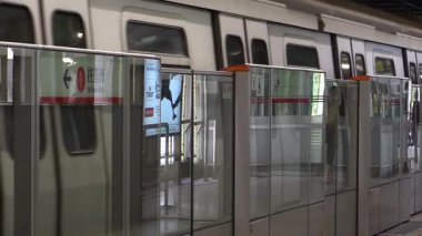 Yoğun metro istasyonunda sabah trafiği başlıyor. Yolcular bekliyor ve trenler sorunsuz geliyor.