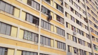 Güneşli bir günde hareketli bir şehir binasının pencerelerine ulaşmak için tırmanan maceraperest bir işçi etkileyici beceri ve cesaret sergiliyor.