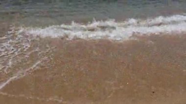 Dalgalar günbatımında kıyıları nazikçe öperek sakin bir sahil atmosferi yaratır.