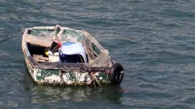 Gün batımında huzurlu bir köyün yakınında sakin bir nehirde renkli bir teknede çalışan bir balıkçının güzel anları.