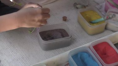 Güneşli bir alanda canlı bir sanat istasyonunda renkleri keşfeden yaratıcı eller