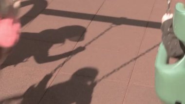 Gölgeler parkta dans eder Neşe parıldar salıncaklarda Altın öğlen ışığında