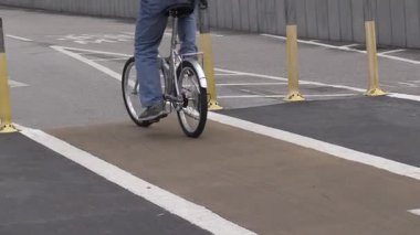 Şehir bisikletçileri güneşli bir günde canlı bir şehir ortamında bisiklet yollarında geziniyorlar.