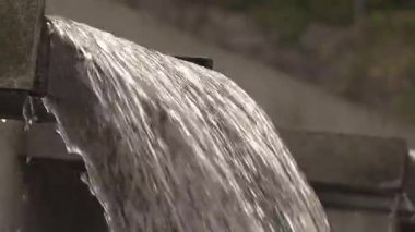 Alacakaranlık vakti büyüleyici bir bahçede çağlayan suyun büyüleyici güzelliği.