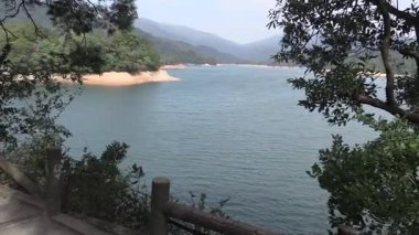 Büyüleyici göl manzarası, yemyeşil tepeler ve sakin sular öğlen vakti sakin bir doğal ortamda yakalanır.