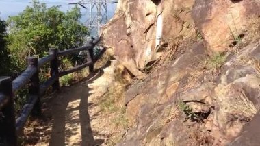 Aşağıdaki şehrin çarpıcı manzarasıyla bereketli doğada dolambaçlı bir patikayı keşfediyorum.