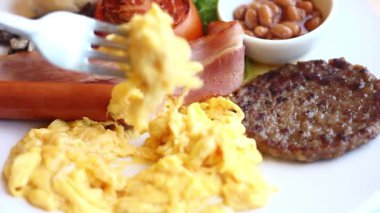 Lezzetli bir sabah ziyafeti, çırpılmış yumurta ve hoş bir ortamda lezzetli kahvaltı klasikleri sunar.