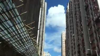 Pofuduk bulutlarla dolu mavi bir gökyüzünün altında hareketli bir şehrin canlı ufuk çizgisini keşfediyorum.