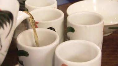 Huzurlu bir çay evinde sıcak bir toplantıda narin fincanlara güzel kokulu çay dökülüyor.