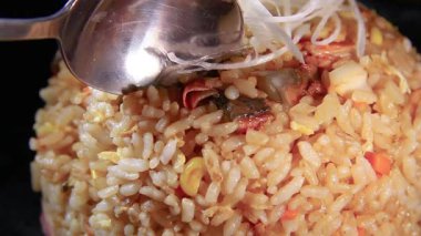 Canlı bir mutfakta canlı malzemeler ve dikkatli karıştırma ile nefis pirinç yemeği hazırlamak.