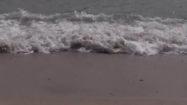 Gün batımında sakin bir sahil cennetinde huzurlu anlar için kumlu sahilde hafif dalgalar dolaşır.