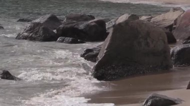 Dalgalar alacakaranlıkta kayalık sahilde dans eder, dinginlik ve güç harmanlanır doğada