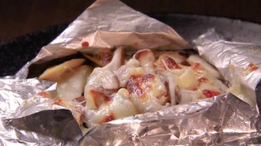 Lezzetli eritilmiş peynir ve folyo ekmeğe sarılmış lezzetli malzemeler, gün batımında sıcak bir lokantadan lezzetli bir ikram.