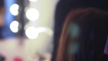 Parlak ışıkları olan şık bir soyunma odasında güzelliği makyaj sanatıyla dönüştürmek.