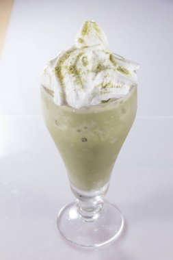 Krem şantili, serpilmiş toz ve özel içecekle kaplı uzun, buzlu kibrit sütlü latte..