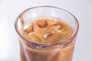 Şeffaf bir bardak buzlu kahve, sütlü girdap ve buz, ferahlatıcı soğuk içecek..