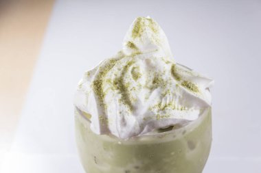 Makro krema tozu, kibrit tozu ile kaplanmış soğuk yeşil çay içeceği, yumuşak dokular ve açık renk..