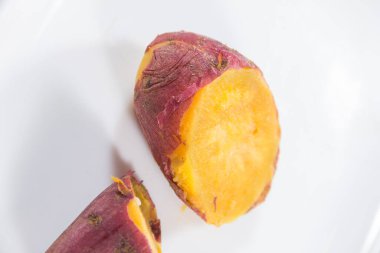 Kızarmış tatlı patatesin taşralı yarıları portakal eti ve yanmış deriyi gösteriyor, içten ve basit..