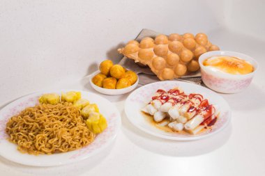 Yumurtalı waffle, pirinç rulosu, siu mai ve erişte içeren çeşitli Hong Kong atıştırmalıkları..