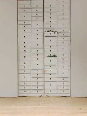 İçeride simetrik desenler oluşturan sayısız küçük çekmeceleri olan uzun bir dolap..