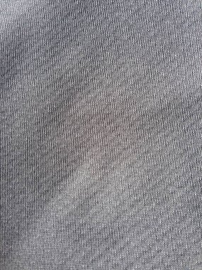 İnce dokuma lifleri ve pürüzsüz dokuyu gösteren gri kumaş yüzeyinin ayrıntılı görünümü.