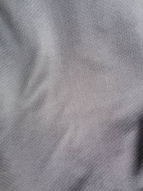 Gri kumaşı kapat, ince dokuma dokusu ve yumuşak kıvrımları göster.