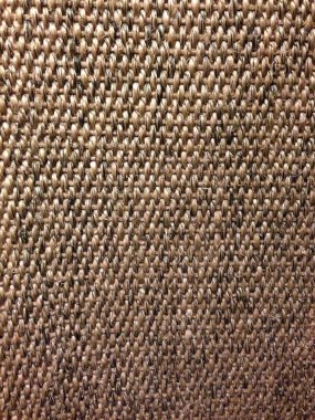 Kalın iplikleri ve desenli yüzeyi gösteren kabaca dokunmuş kumaşın yakın çekimi