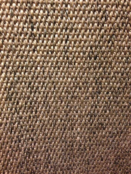 Kalın iplikleri ve desenli yüzeyi gösteren kabaca dokunmuş kumaşın yakın çekimi