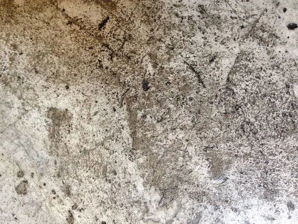Kaba doku ve koyu düzensiz izler gösteren lekeli beton duvarın yakın çekimi