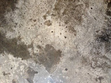 Koyu lekeler ve pürüzlü dokuları gösteren yıpranmış beton duvarın yakın çekimi